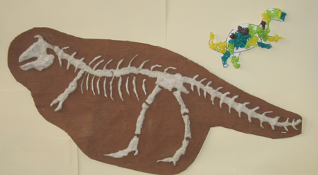 Children create a dinosaur skeleton out of tissue paper.
