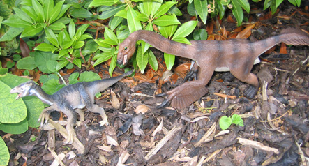 Dinosaurs play chase in the shrubbery.