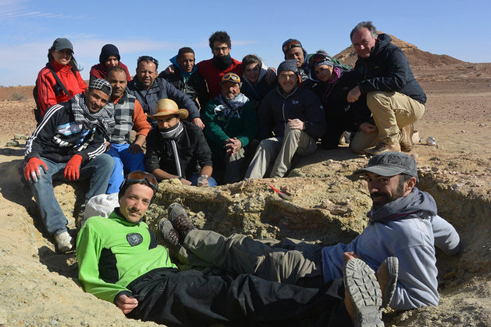 The field team pose with the fossilised skull.