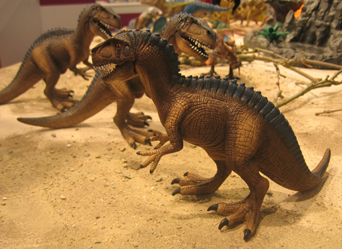 Schleich Acrocanthosaurus dinosuar model playing in the sand.