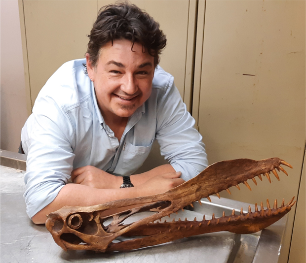 PhD student Tim Richards poses with a cast of the skull and jaws of an anhanguerid pterosaur.