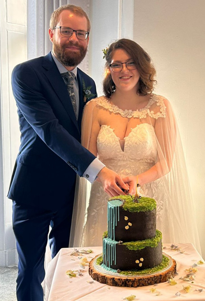 Cutting the dinosaur themed wedding cake.